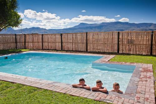three children are laying in a swimming pool at Wagon Wheel Country Lodge in Beaufort West