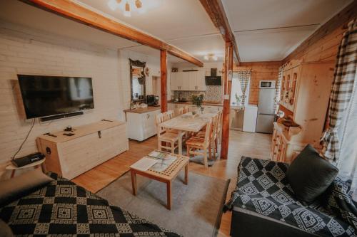 a living room with a table and a kitchen at Sielanówek - Orzechowa Chatka z sauną wanną termalną jacuzzi in Żywiec