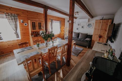 a dining room and living room with a table and chairs at Sielanówek - Orzechowa Chatka z sauną wanną termalną jacuzzi in Żywiec