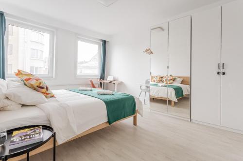 a white bedroom with a bed and a walk in closet at Center of Antwerp, Fully Equipped, Train Station in Antwerp