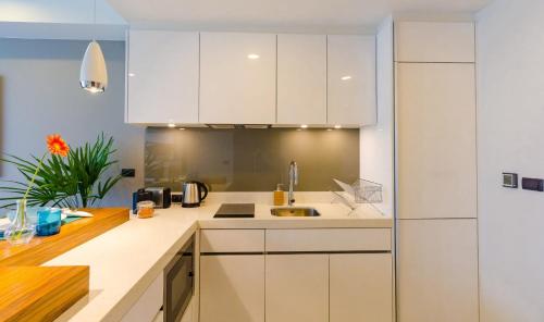 a kitchen with white cabinets and a sink at OceanStone 1-BR next building view in Bang Tao Beach