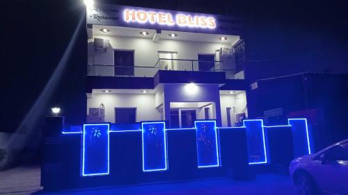 a building with a blue neon sign in front of it at OYO Hotel Bliss in Rewāri