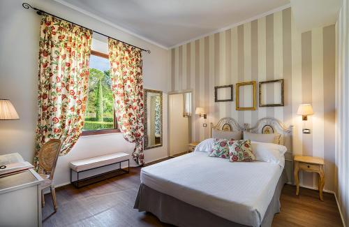 a bedroom with a white bed and a window at San Giovanni Terme Rapolano in Rapolano Terme