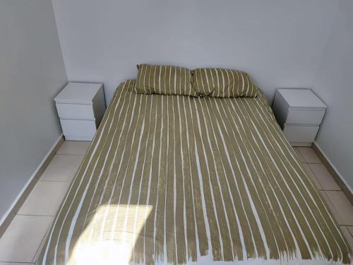 a bed in a room with two drawers at Charmant appart à 15 minutes de la plage et du centre ville M'DICQ, TETOUAN in M'diq