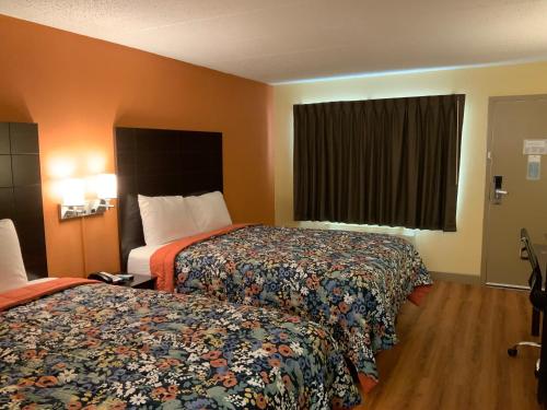 a hotel room with two beds and a window at Days Inn by Wyndham Troy IL in Troy