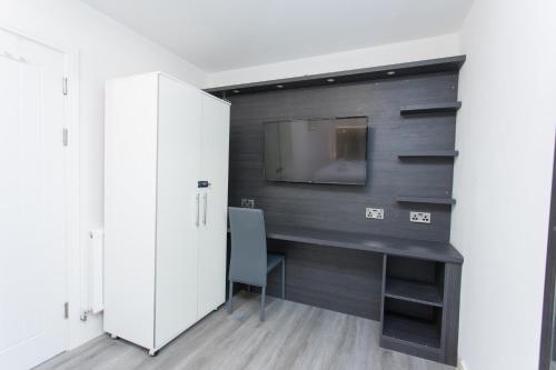 a room with a desk and a tv on a wall at Legoland Heathrow Windsor Apartment Hotel in Slough