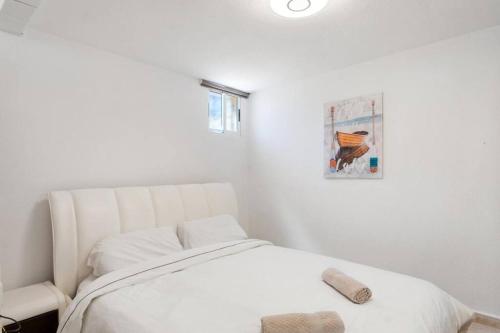 オリウエラにあるHE Sunny Terrace Bの白いベッドと壁の絵が備わるベッドルーム1室が備わります。