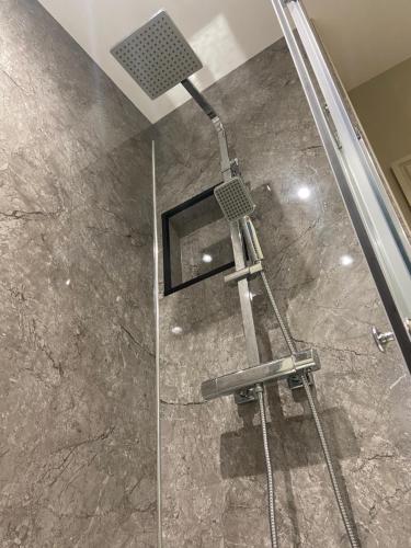 a shower with a glass door in a bathroom at Cosy small cottage in Wirral Merseyside with kitchen in Lower Bebington