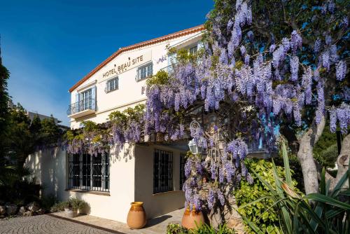 un edificio con un árbol de glicina delante de él en Hôtel Beau Site - Cap d'Antibes, en Antibes