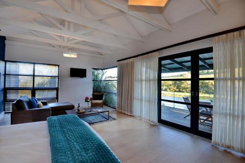 a bedroom with a bed and a living room at Ladybird Lodge in Stellenbosch