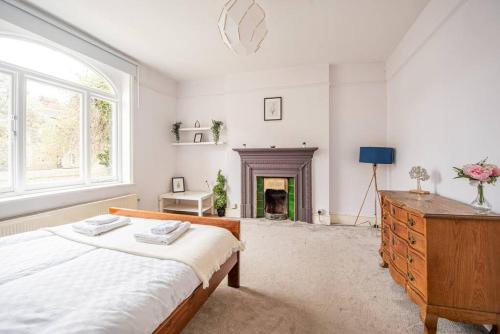 - une chambre avec un lit et une cheminée dans l'établissement Bright Spacious Maida Vale Flat 5 - minutes from Station, à Londres