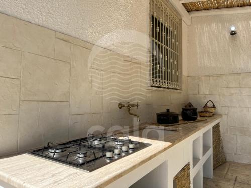 a kitchen with a stove top on a counter at Villa Sebastia - 100m dalla spiaggia By Cala Salento in Torre Lapillo