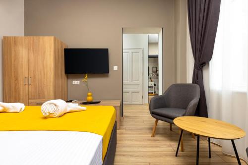 a bedroom with a bed and a chair and a table at Kapana Guest House on Central Pedestrian street with Parking included in Plovdiv