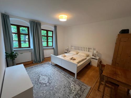 een slaapkamer met een bed en een tafel en stoelen bij LIBORIA II Wohnen im Denkmal Augsburgs in Augsburg