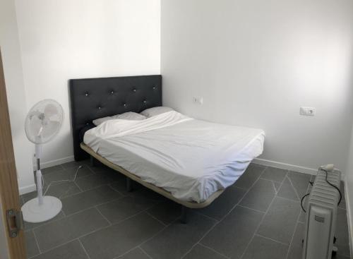 a small bedroom with a bed with a fan at BEL APPARTEMENT ROSES PLAGE in Roses