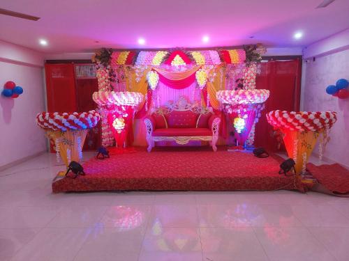 伽耶的住宿－POP Divisha Palace，一间红色的床铺,粉红色的房间