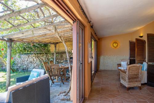a patio with a table and chairs and a window at Porto Cervo Centro con piscina, Le Terrazze del Porto in Porto Cervo