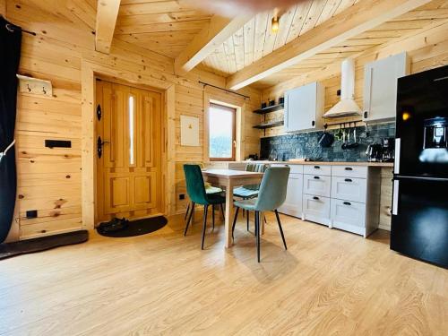 a kitchen with a table and chairs in a cabin at Osada Foltynówka in Soblówka