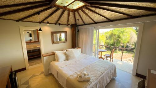 ein Schlafzimmer mit einem Bett und einem großen Fenster in der Unterkunft Pousada Ao Por do Sol in Búzios