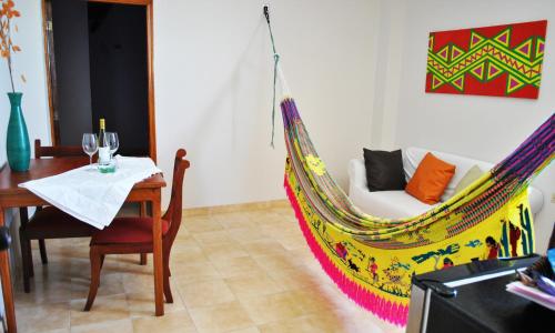 a room with a table and a hammock bed at Hotel Majayura Sol in Ríohacha