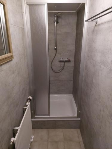 a bathroom with a shower with a tub and a sink at Appartement met inpandig balkon, 150 meter verwijderd van strand en centrum in Zoutelande