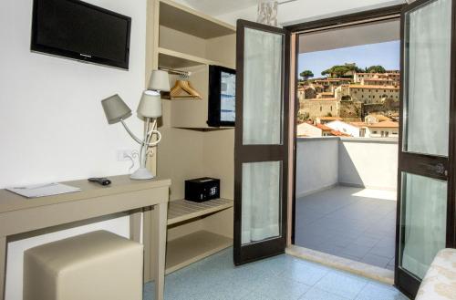 a room with a balcony with a view of the city at Hotel Lucerna in Castiglione della Pescaia