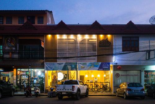 un camión blanco estacionado frente a un edificio por la noche en Paknap Hostel en Nan