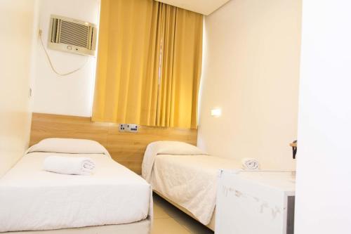 a hospital room with two beds and a tv at Minuano Hotel Home próximo ao aeroporto in Porto Alegre