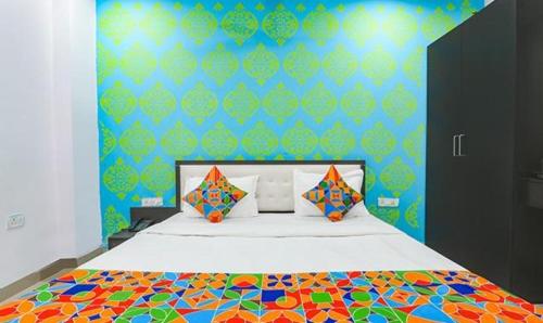 1 dormitorio con 1 cama grande y edredón colorido en FabExpress Happy Mark Inn, en Lucknow