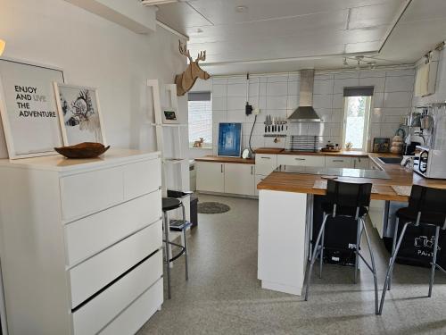 uma cozinha com armários brancos e uma mesa em The Northern Light Apartment em Jukkasjärvi