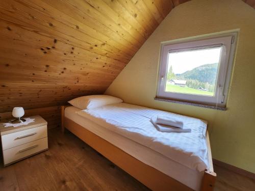 a small bedroom with a bed and a window at Cottage Zoja in Bohinjska Bistrica