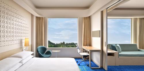 a hotel room with a bed and a desk and a window at Fairfield by Marriott Hyderabad Gachibowli in Hyderabad