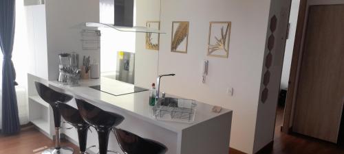 Habitación con escritorio blanco con sillas negras. en Wohnung Queens Deluxe, en Bogotá