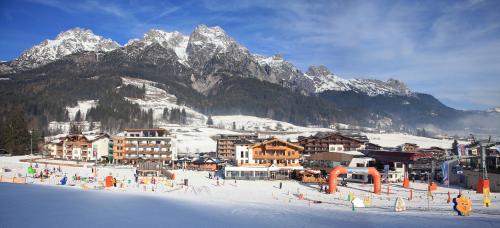 a town in the snow with a mountain in the background at Tarlack Appartements Hütten 34 in Leogang