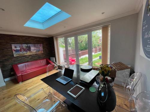 a living room with a table with two laptops on it at Family Home with fast trains to London Bridge, Victoria, Gatwick and Wimbledon in Croydon
