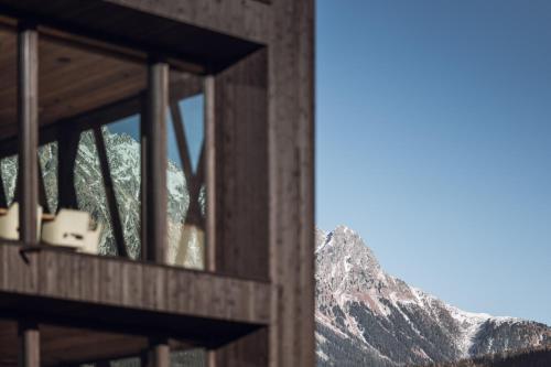a building with a view of a mountain at Amus Suites Dolomites in Anterselva di Mezzo