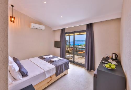 a hotel room with a bed and a balcony at Cinar Butik Hotel in Kaş