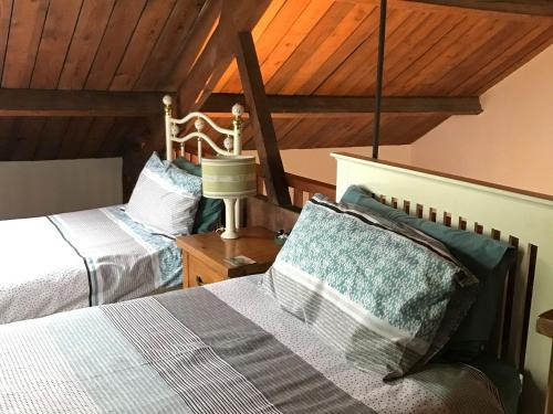 two beds in a room with wooden ceilings at Swan in Welney