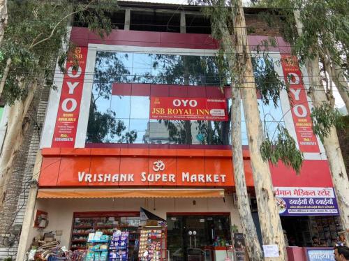 a store in a city with trees in front of it at OYO Jsb Royal Inn in Muzaffarnagar