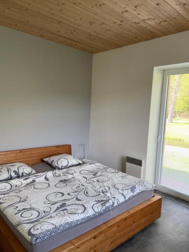 a bedroom with a bed with a wooden headboard and a window at River wellness in Jince