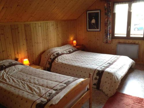 a bedroom with two beds in a wooden cabin at Gîte de la Marandine in Métabief with garden in Métabief