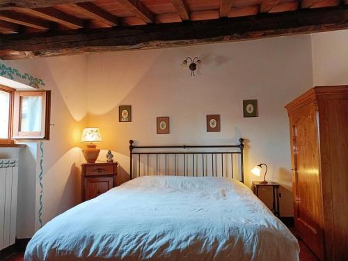 een slaapkamer met een groot bed en 2 nachtkastjes bij Renaissance House in Pienza