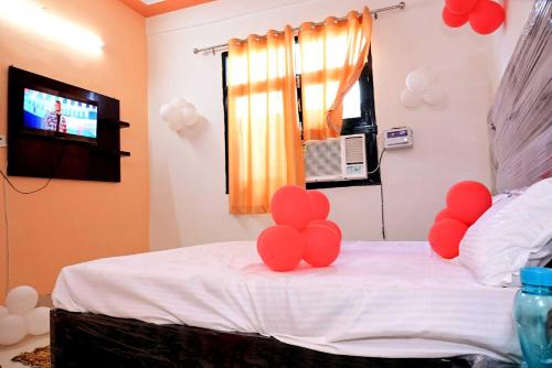 1 dormitorio con globos rojos en una cama con TV en SPOT ON Hotel Heaven Inn, en Panchli