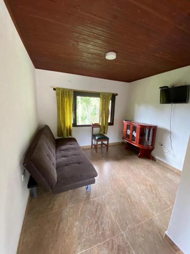 a living room with a brown couch and a television at Hacienda Buenos Aires en Iza in Iza