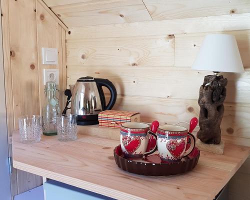 a table with two tea cups and a lamp on it at LE NOYER DU BARON in Le Lauzet-Ubaye