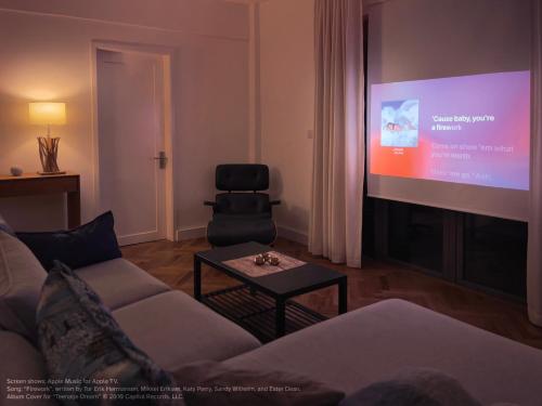 a living room with a couch and a large screen at Phoenix Valley Suite - Exclusive Apartment + Pool in La Caverne