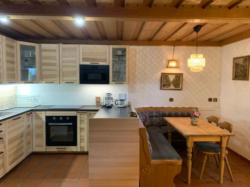 uma cozinha com armários brancos e uma mesa de madeira em Lilly Chalet- Apartments with private sauna, close to ski lifts em Bad Kleinkirchheim
