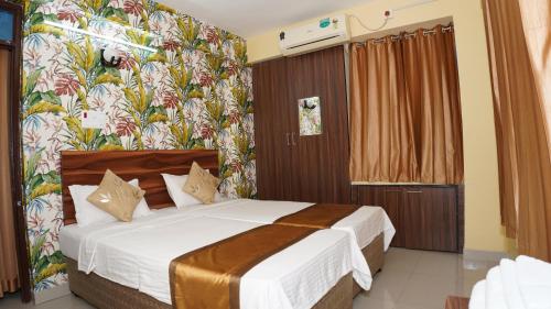 ein Schlafzimmer mit einem Bett in einem Zimmer in der Unterkunft The Royals Home Stay in Deoghar