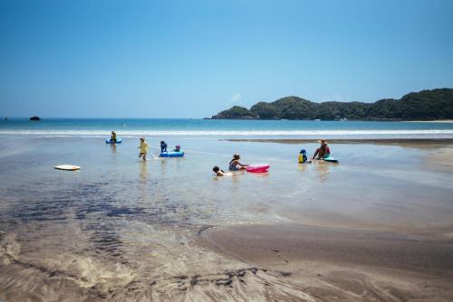 a group of people playing in the water on the beach at Villa Yumigahama in Minamiizu