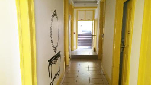 a hallway with yellow walls and a tile floor at Meeting Hostel in Figueira da Foz